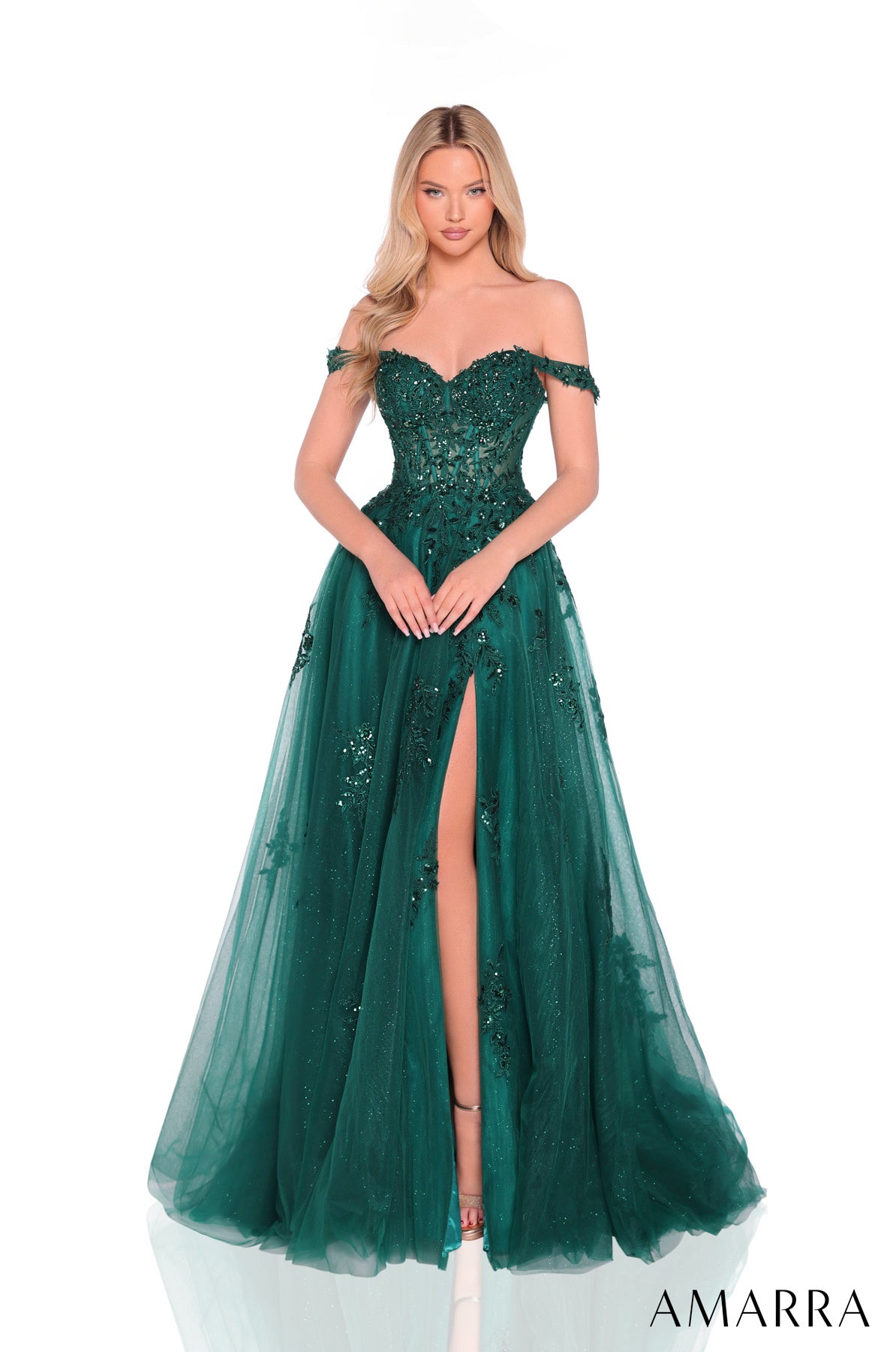 Woman wearing a green evening gown with a high slit on a white background, brand 'AMARRA' visible.