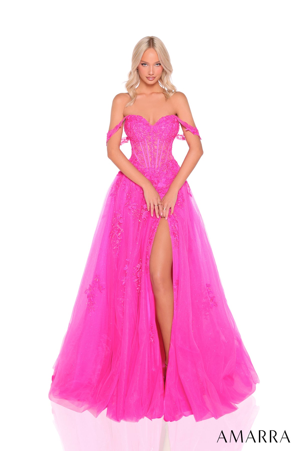 Woman wearing a pink evening gown with a high slit on a white background, brand 'AMARRA' visible.