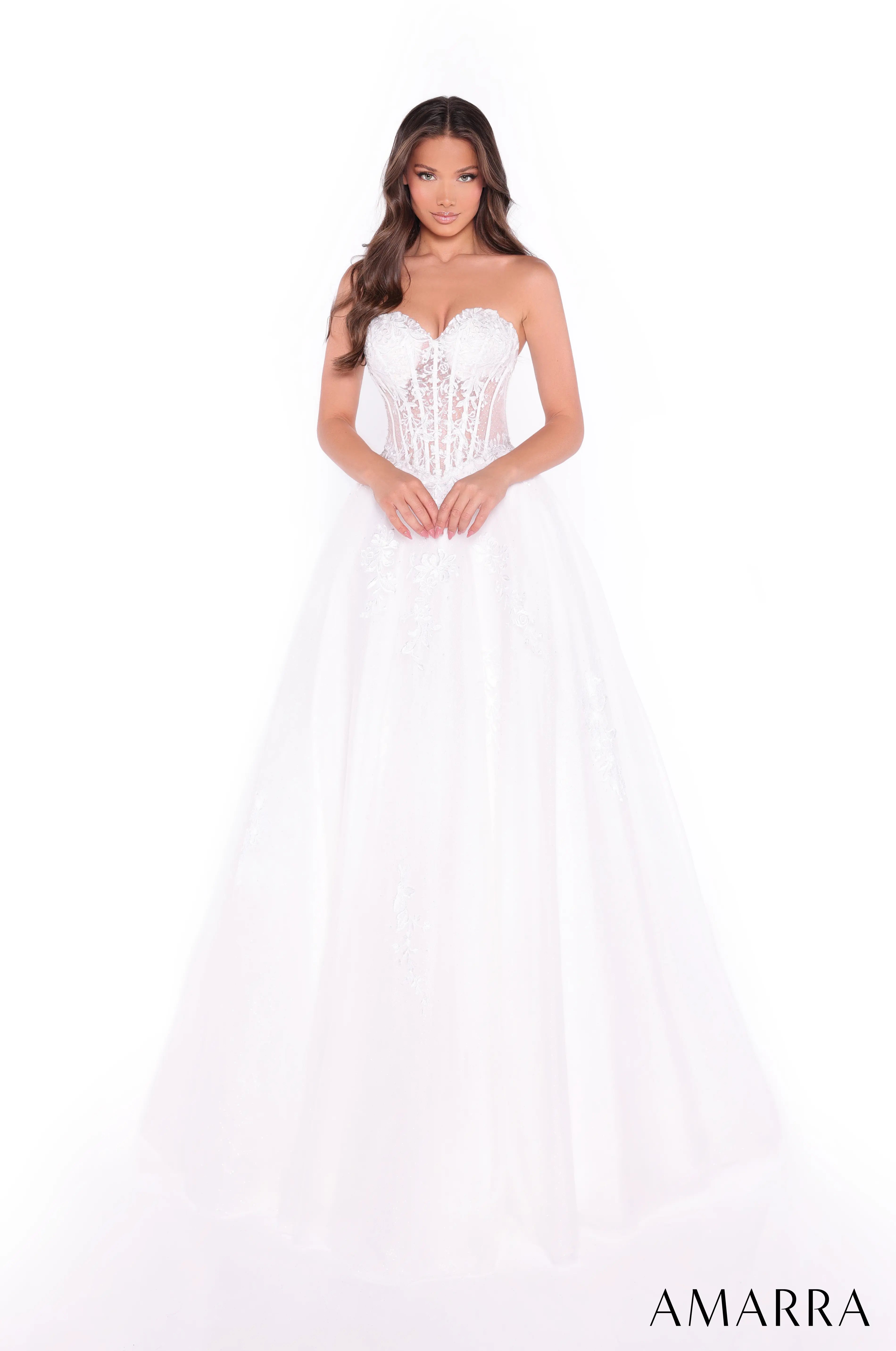 Woman wearing a white strapless dress with lace details on a white background, featuring the brand 'AMARRA'. ONLY AT THE BRIDAL COMPANY