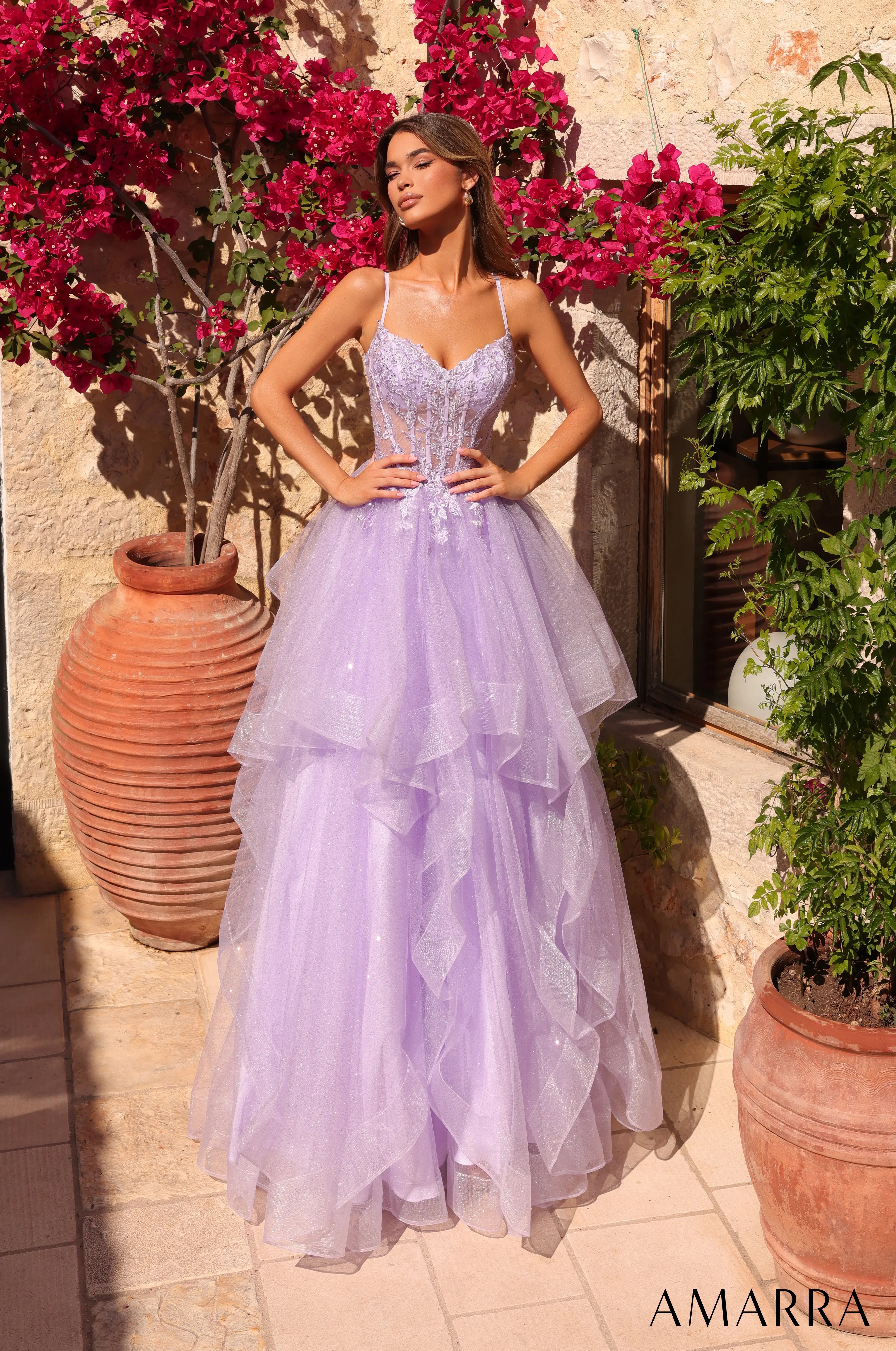 Woman in a lavender gown standing outdoors with flowers and plants around.  at the bridal company brisbane gold coast