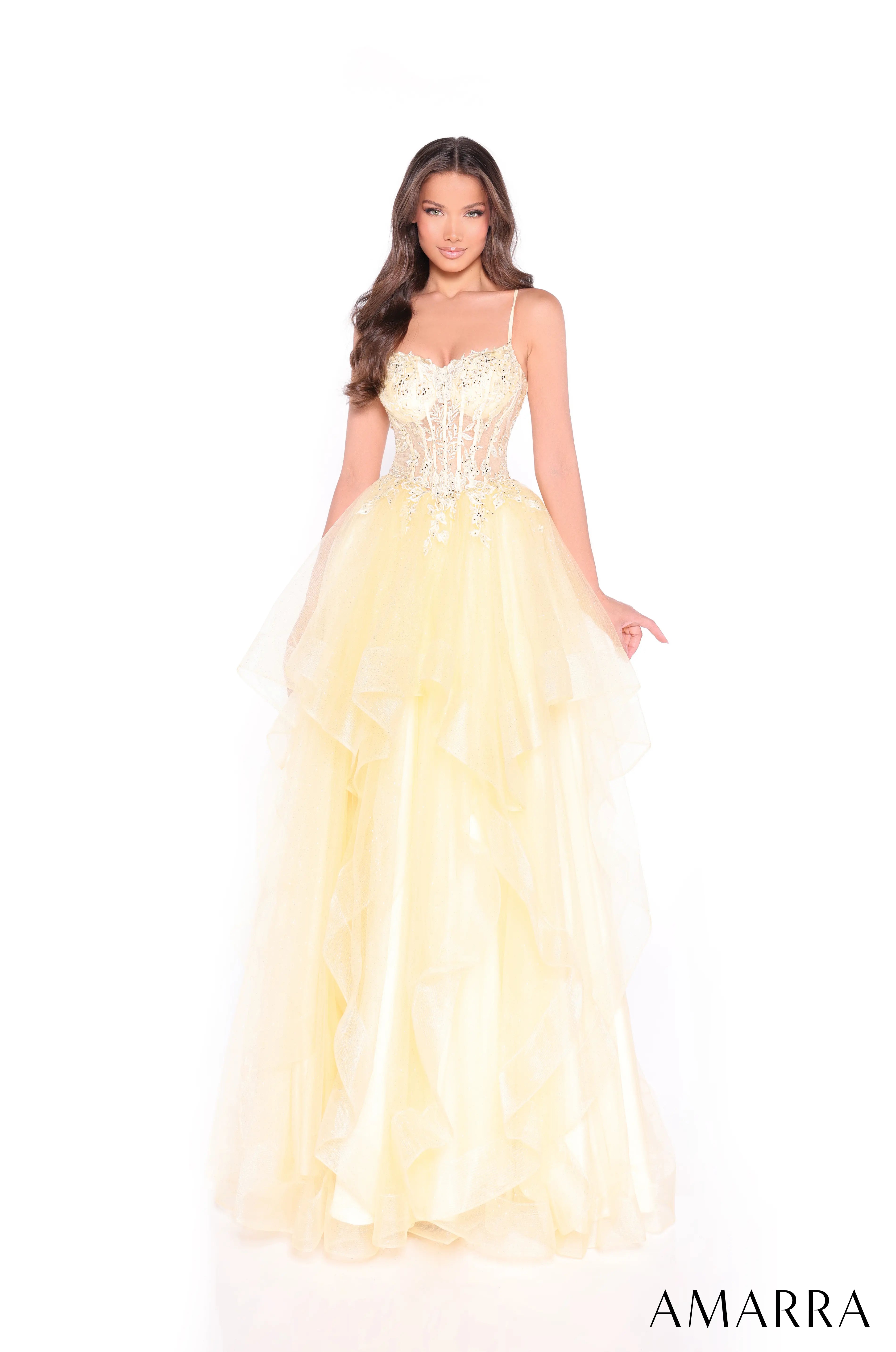 Woman wearing a yellow evening gown with floral details on a white background, brand 'AMARRA' visible.  at the bridal company brisbane gold coast