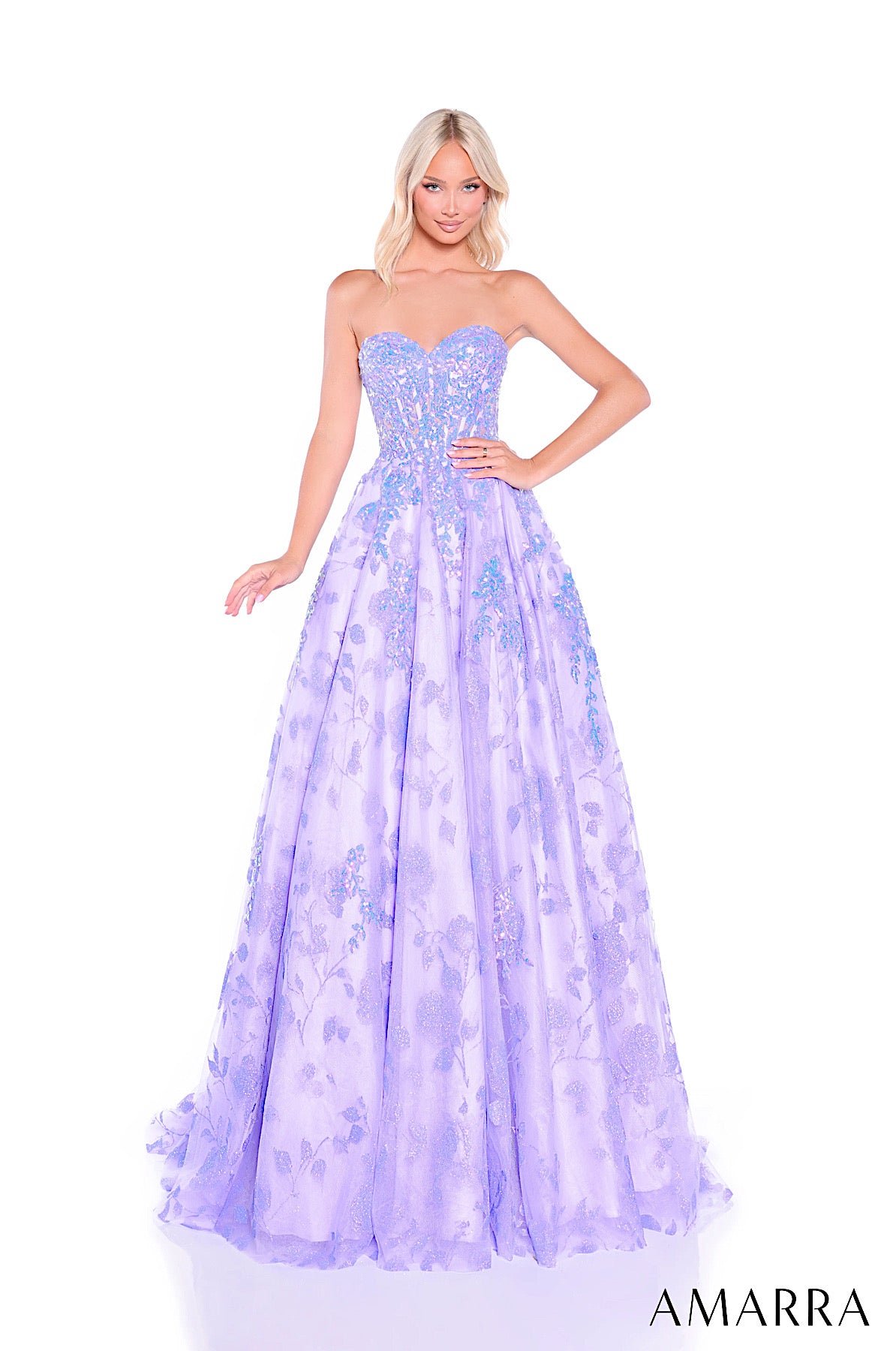 Woman wearing a strapless, light purple evening gown with floral patterns on a white background. Brand 'AMARRA' visible.