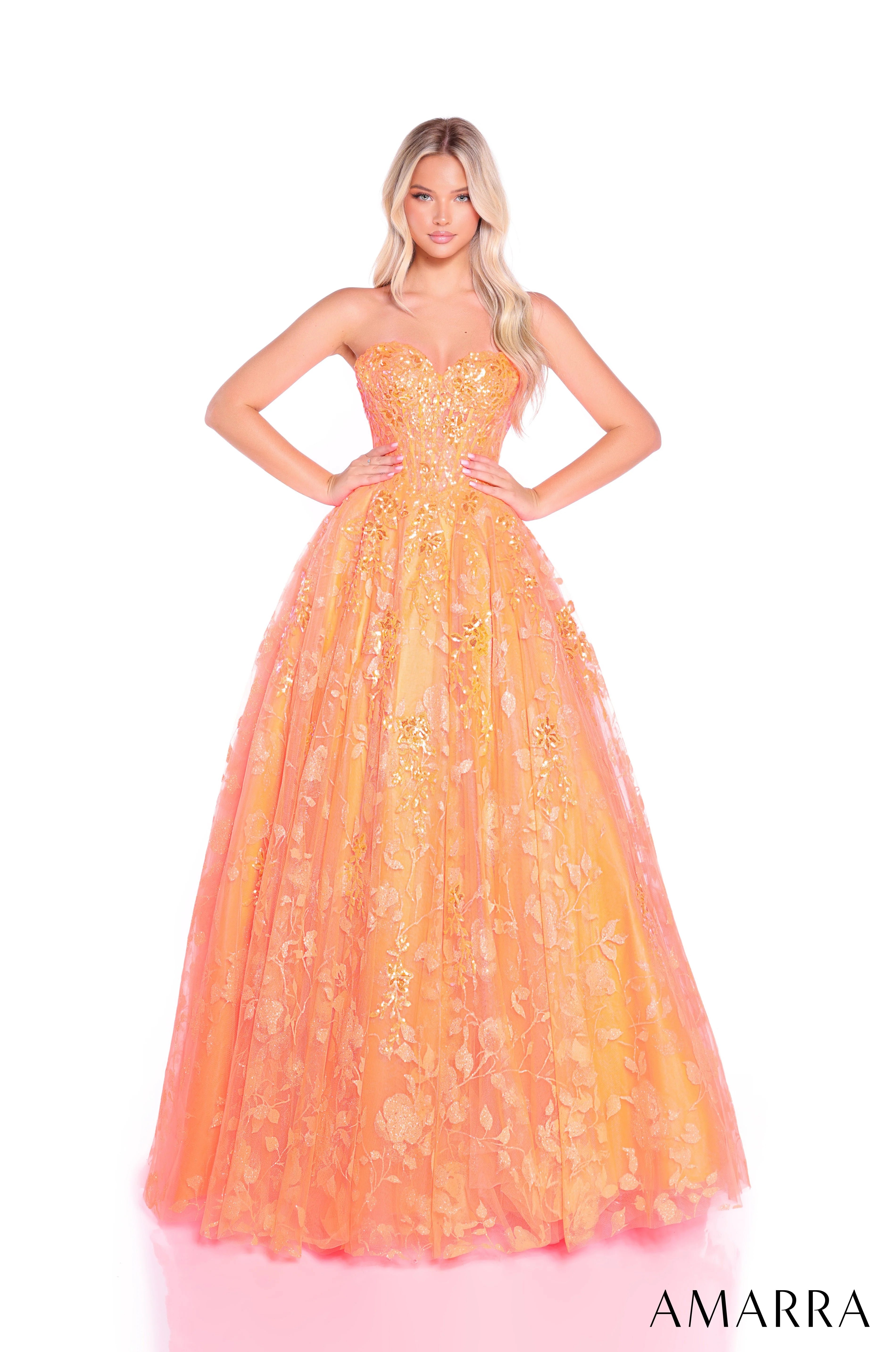 Woman wearing a strapless, floor-length orange dress with floral patterns on a white background. Brand 'AMARRA' visible.