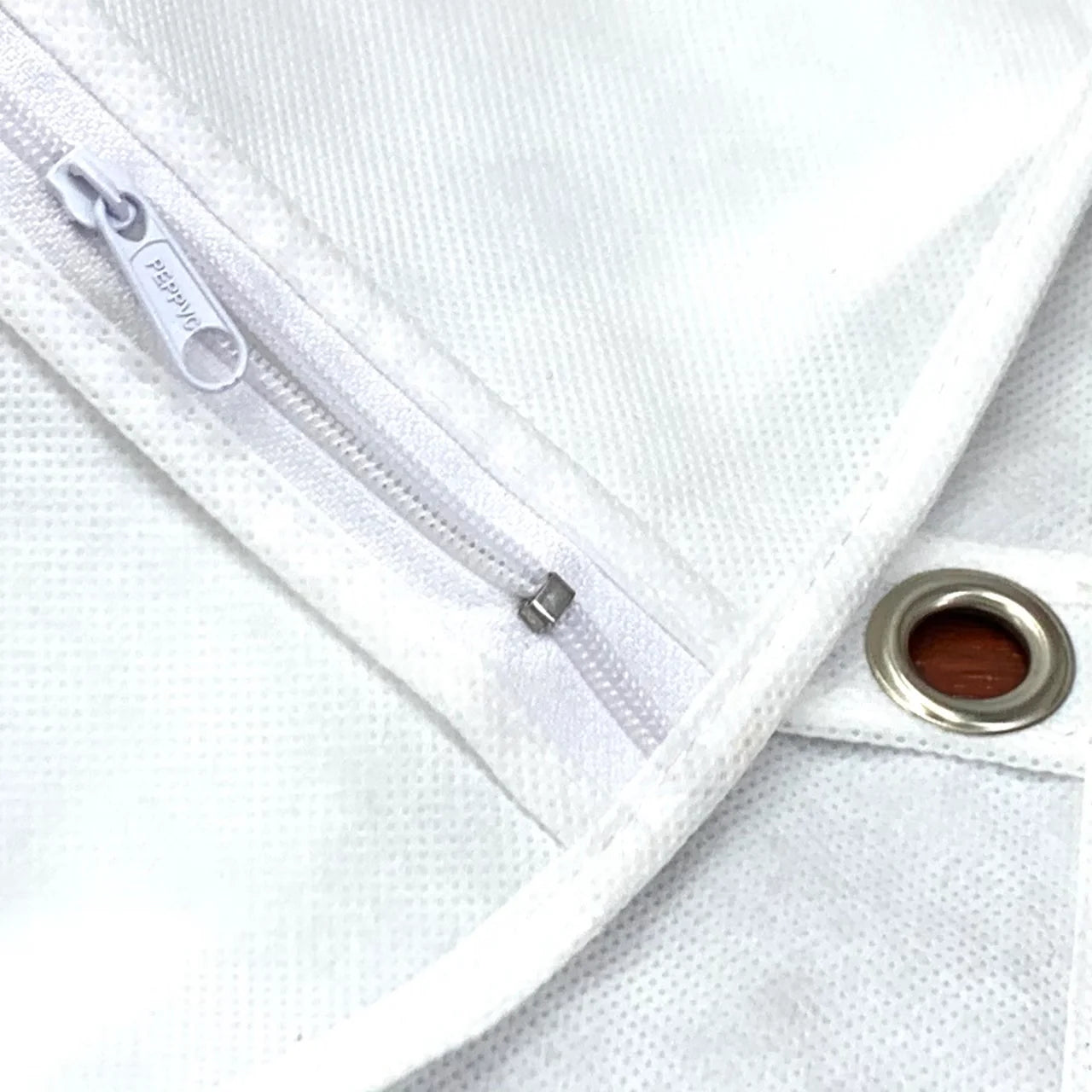 Close-up of a white curtain with a zipper and grommet detail.